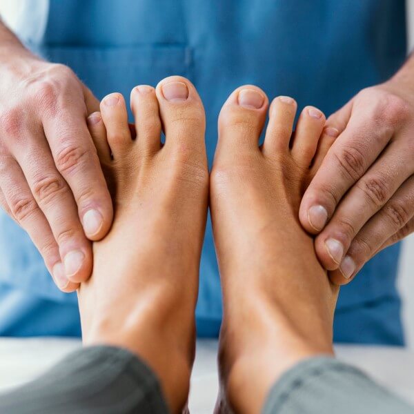 Medical professional examining a patient's bare feet.